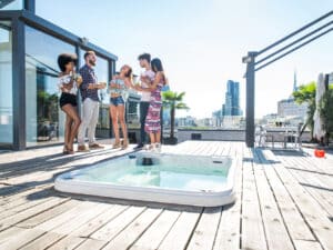 Groupe d'amis autour d'un spa sur un rooftop