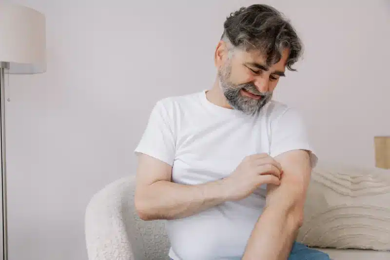 Homme qui se gratte à cause des puces