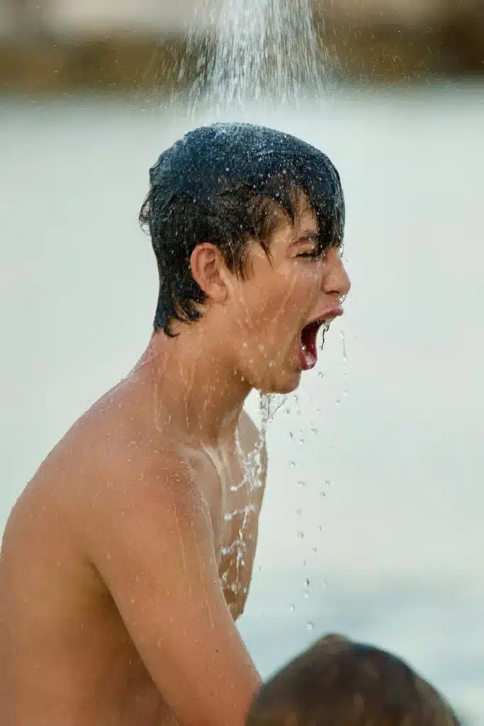 Jeune prenant une douche d'extérieur